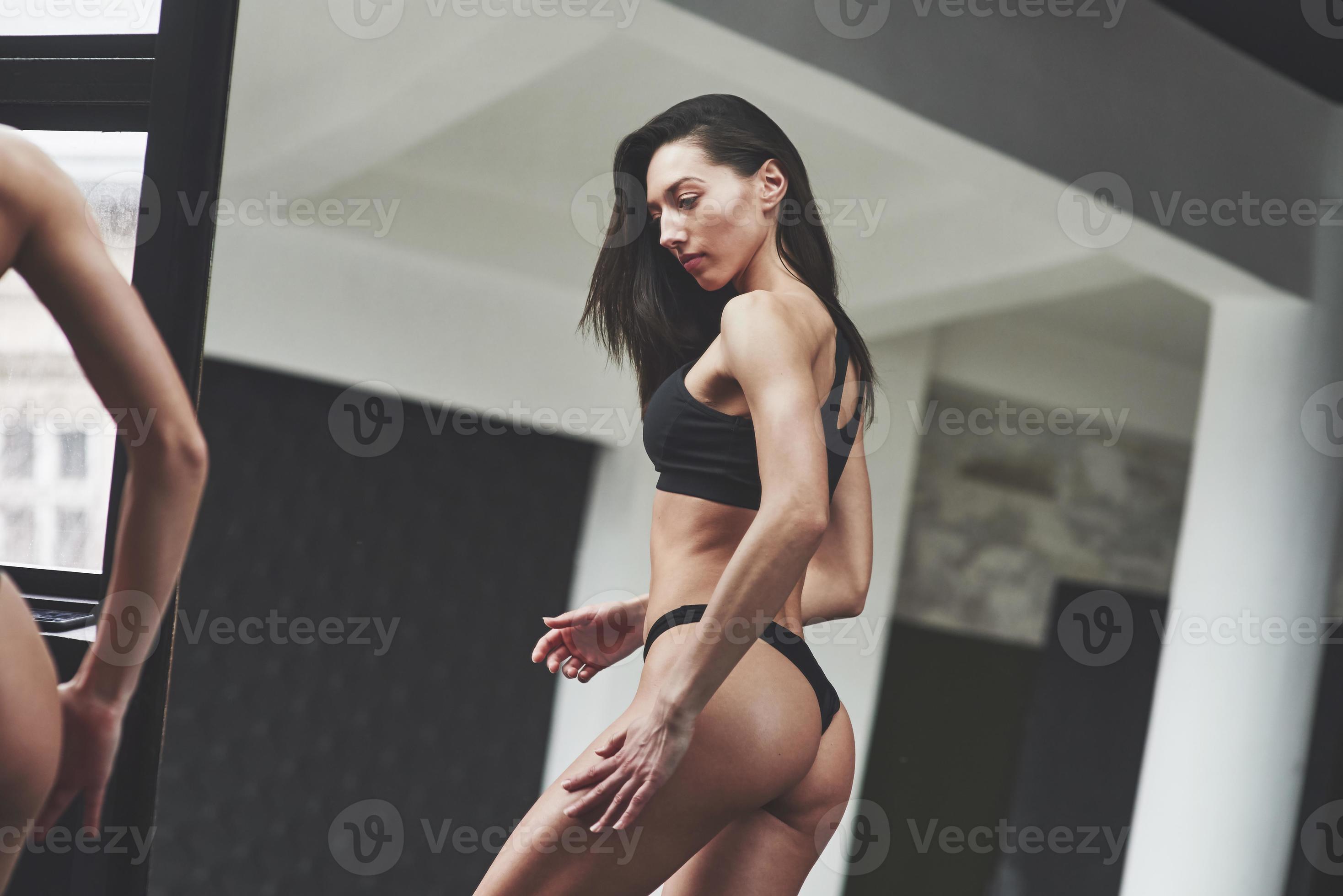 Results Of Workout Particle View Of Hot Slim Body Type Of Girl That Stands In The Room