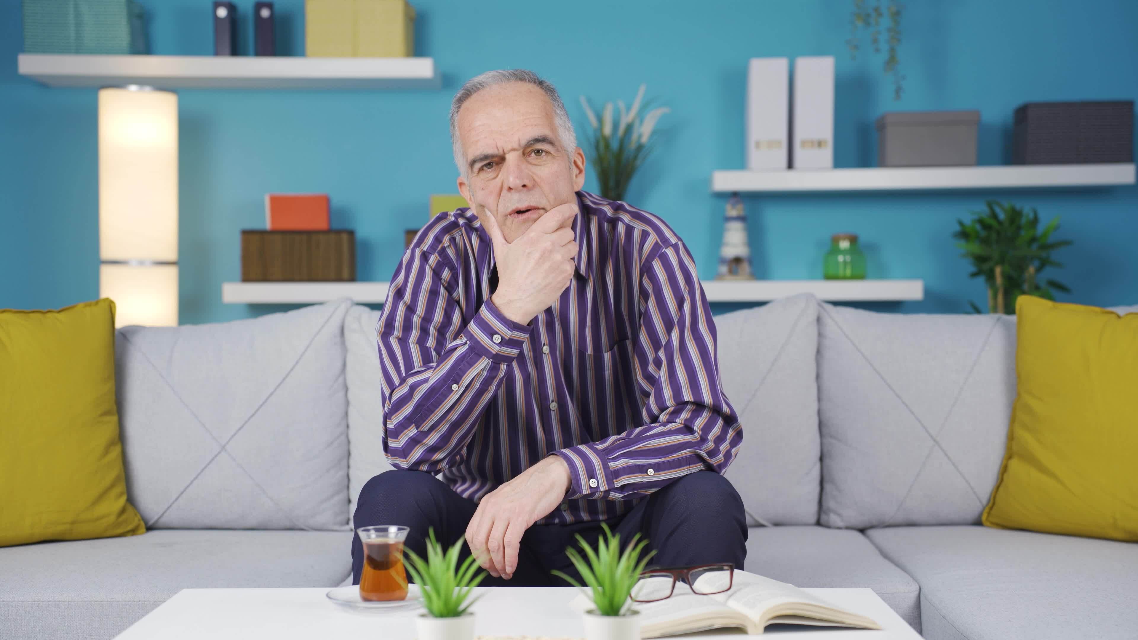 une mature homme à Accueil est écoute à le caméra avec plein attention Vidéo de stock