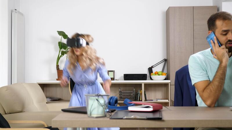 Beautiful Blonde Woman Explores Virtual Reality While Her Partner Is Talking On The Cellphone