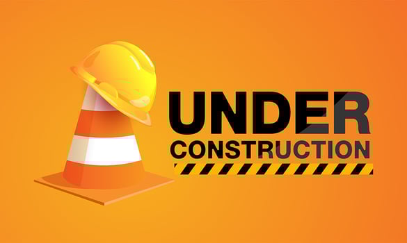 Under construction sign with hat on traffic cone vector