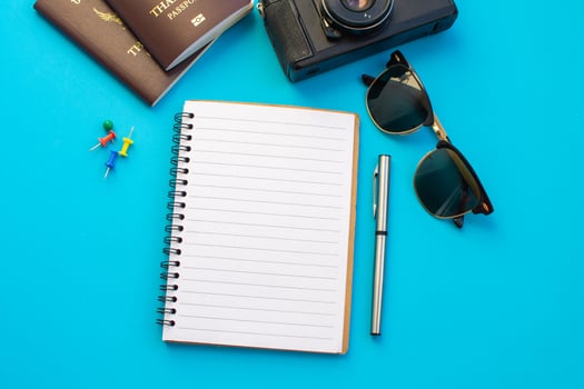 Flat lay of notebook surrounded by travel items  photo