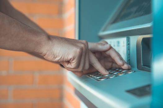 Bank customer enters  credit card code in ATM machine photo