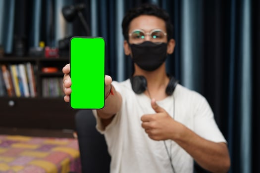 Young Indian boy holding a phone with green screen photo