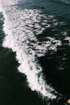 Aerial of person standing among waves photo