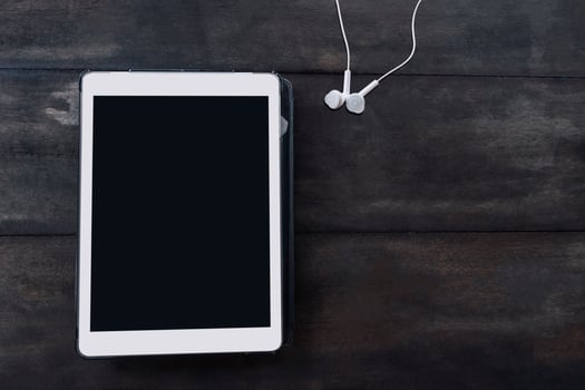 Flat lay of tablet and headphones photo