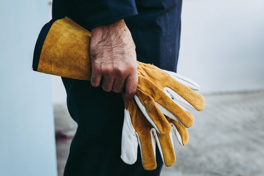 Closeup of man holding yellow work gloves photo