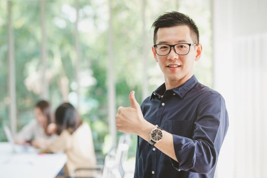 Asian businessman smiling with thumbs up gesture photo
