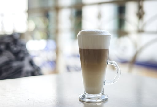 Latte in clear mug on table photo