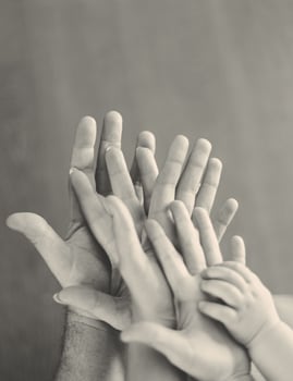 Grayscale of family's hands photo