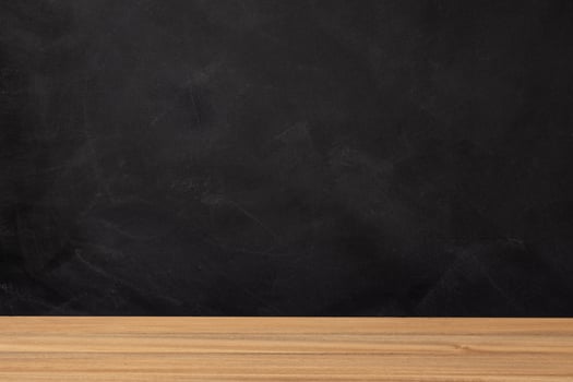 Wooden table and blank chalkboard background photo