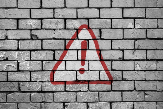 Warning sign painted on a brick wall photo