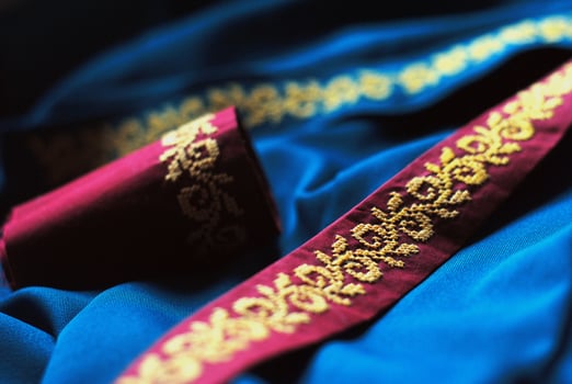 Embroidered ethnic ornament on red ribbon, cross stitch photo