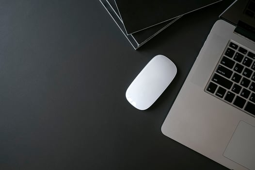 Laptop, mouse and books on a black table photo