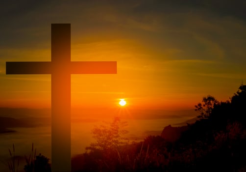 Cross on a mountain during sunrise photo