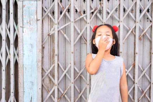 Little Asian girl wearing a mask yawning photo