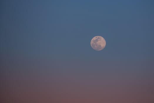 Pastel sunset with moon in sky photo