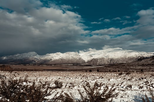Snow covering grass and mountains photo