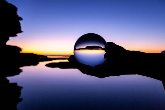 Person holding glass ball at sunset photo