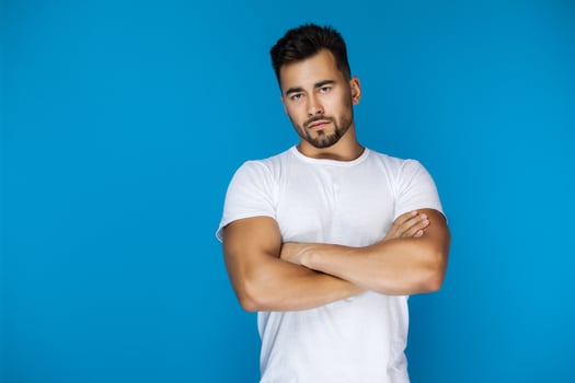 Man with crossed arms looks seriously at the camera photo