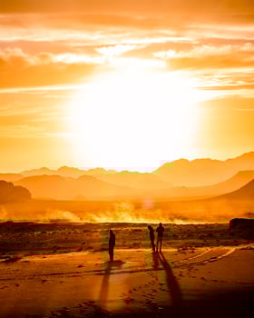 Three men at the sand dunes during golden hour photo