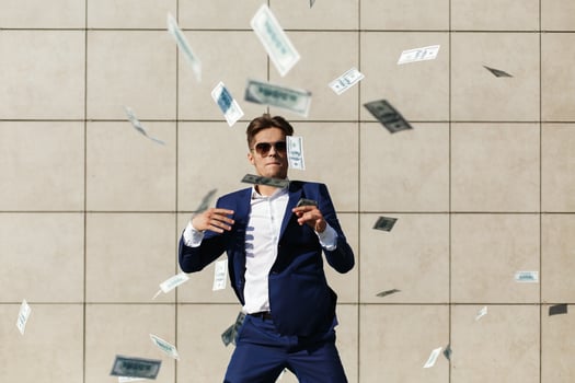 Young businessman throws around dollars and dances on the street photo
