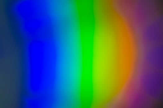 A rainbow colored light is shown in a dark room photo