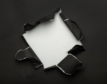 Black torn paper on white background photo