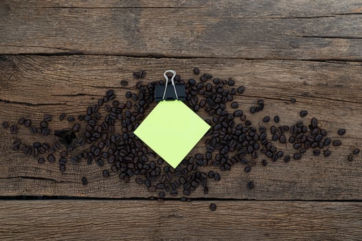 Wooden desk with coffee beans and note pad photo