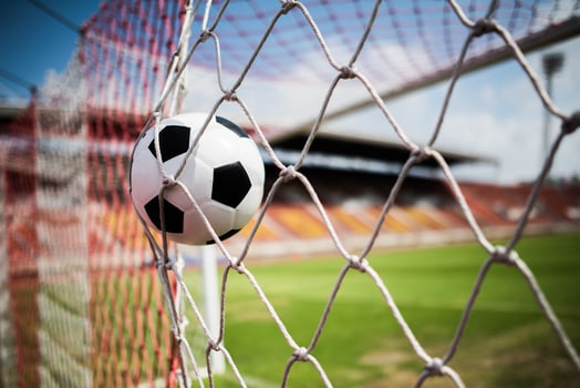 Soccer ball soars into goal net photo