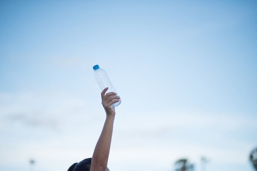 Woman's hand holding a plastic water bottle photo