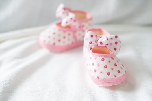Newborn shoes on white bedding photo