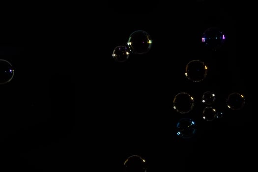 Soap bubbles floating in the air on a black background photo