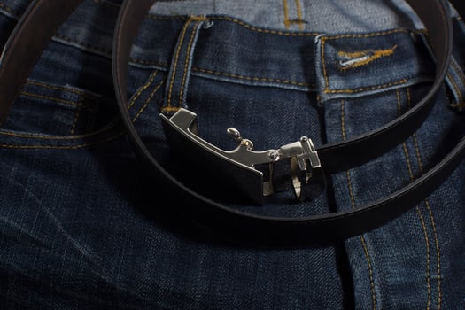 Detail of jeans with black leather belt closeup. photo