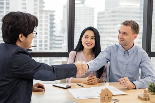 Couple shaking hands as successful agreement in transaction contract of house with broker. photo
