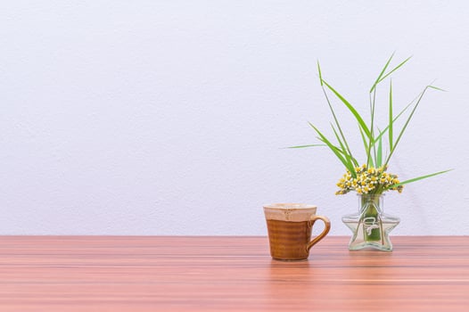 A vase with flowers and a coffee cup on a table photo