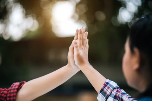 Two young college students giving high fives to each other photo