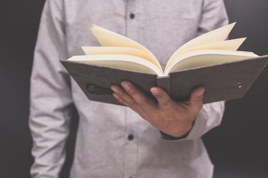 A man is holding an open book photo