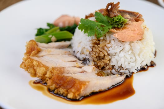 Crispy pork on a white rice topped with sauce photo