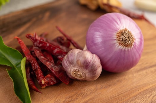 Red onion, pepper and lime leaves on a wooden table photo