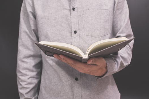 A man is holding an open book in his hands photo