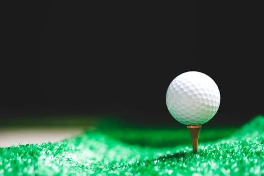 Close-up of golf ball on tee at night photo