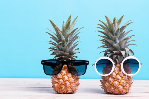 Two pineapples wearing sunglasses photo
