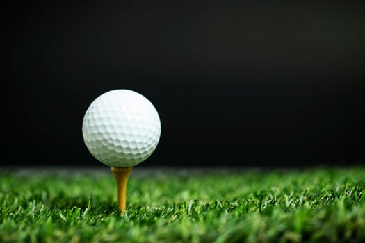 Golf ball on tee at night photo