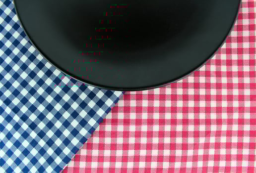 Black plate on checkered tablecloth photo