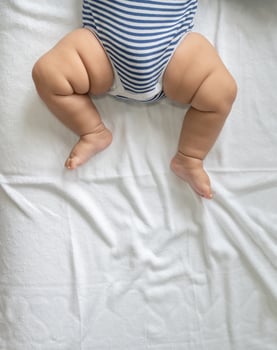 Baby's feet in a white bed photo