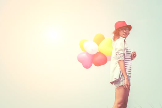Young beautiful woman holding balloons in the fresh air photo