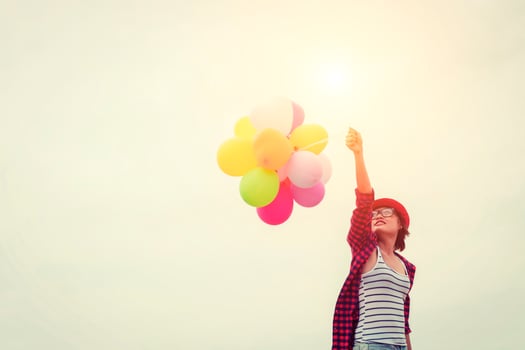Young beautiful woman holding balloons in the fresh air photo