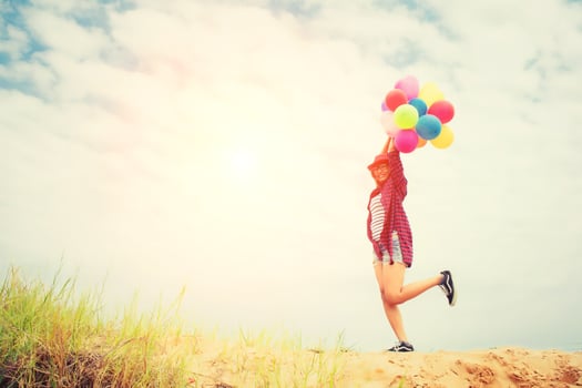 Young beautiful woman holding balloons in the fresh air photo
