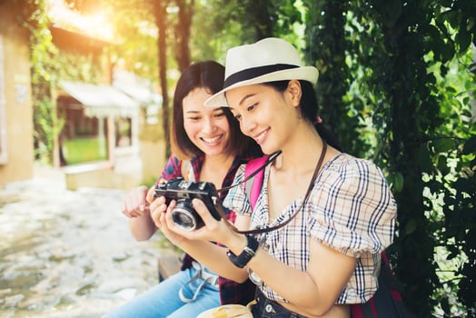 Two woman having a good time sitting at a bench photo