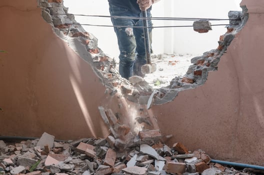 Man demolishing the walls of a house photo